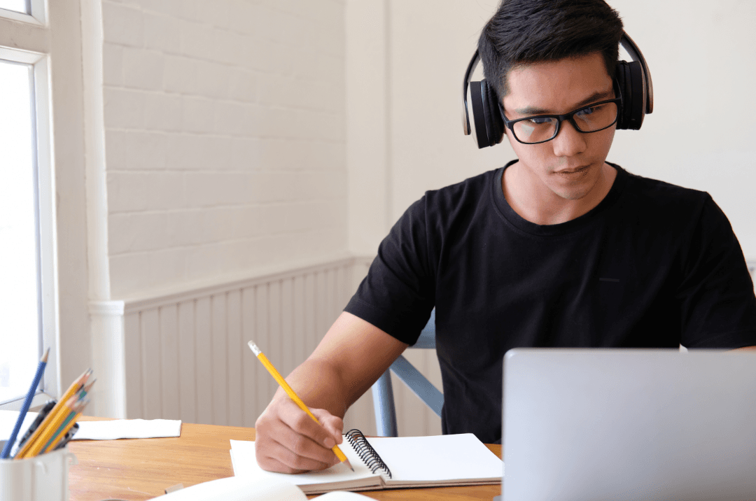Student studying medical coding online with headphones and laptop